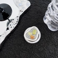 Macro view of heart-shaped gems inside a wavy resin grip tok on a black background - Green Smudge Double Heart Style