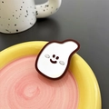 Detail view of a banana-shaped mirror phone grip with a minimalist smiley face design - Brown