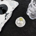 Detail showing an irregular silver frame phone grip with green gemstone and pearl inlay - Green Smudge Pearl Cat Eye Style