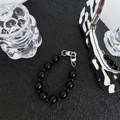 Close-up of a minimalist black beaded phone strap with high-gloss finish and silver clasp - Black Beaded Chain Of Varying Sizes
