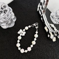 Detail of pearlescent beaded phone strap with a white bow and silver lobster clasp - Laser Bow Tie Chain
