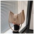Detalle del bolso de media luna beige con una gran hebilla en D dorada y textura lisa - Caqui