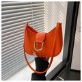 Primer plano de bolso media luna naranja vibrante con detalle de hebilla en U dorada - Naranja