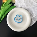 Détail du support de téléphone miroir ours bleu posé sur un plateau en céramique blanche - Support d'Ours Magnétique - Bleu