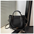 Detail of matte black leather tote bag with gold hardware and iconic triangle metal plate - Black