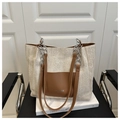 Detail der geflochtenen Stroh-Tasche mit brauner Ledertasche und silberner Kette - Braun