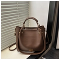 Detail of brown leather tote bag with gold metal handle hinges and adjustable shoulder strap - Brown