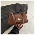 Close-up of brown textured shoulder bag featuring woven pattern and silver star buckle - Tan