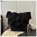 Detalle de un bolso tote negro con volantes y pliegues en una mesa de estilo minimalista - Negro