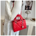 Detail van rode gewatteerde PU-handtas met zilveren hardware en een kettingriem - Rood