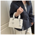 Detail van witte gewatteerde handtas met zilveren bolhanger en ketting aan het handvat - Wit