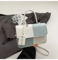 Detail van een kleurgeblokte leren crossbodytas met crème en lichtblauwe vlakken - Blauw