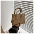 Detailopname van kaki geweven handtas met fijne textuur en goudkleurige hardware - Khaki