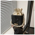 Detail of black snake pattern bucket bag with pearl handle and golden chain strap - Black