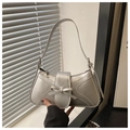 Detail of silver metallic underarm bag with streamlined stitching and bow decoration - Silver