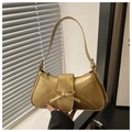 Close-up of golden quilted shoulder bag with bow detail and sleek metallic finish - Gold