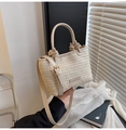 Detail der cremefarbenen Webhandtasche mit Knotengriff und goldfarbenen Metallbeschlägen - Gebrochenes Weiß