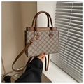 Dettaglio di un'elegante borsa tote con motivo a quadrifoglio e manici in pelle marrone - Monogramma Vintage Caffè