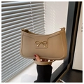 Detalle del bolso hobo beige de media luna con un lazo decorativo de metal dorado - Caqui