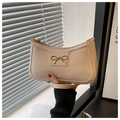 Detalle del bolso de hombro blanco crema con hebilla de lazo dorada y correa elegante - Blanco