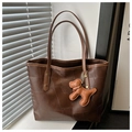 Dettaglio borsa tote patchwork marrone scuro con ciondolo a forma di cane in pelle - caffè