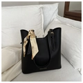 Dettaglio della borsa tote nera con cuciture bianche, logo e foulard di seta decorativo - Stile con cuciture bianche a contrasto / Nero
