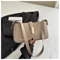 Detalle de bolso de hombro minimalista en cuero beige con elegante cierre dorado - Caqui