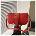 Detalle de bolso rojo con hebilla de herradura dorada y textura de cuero mate - Rojo