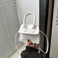 Mini borsa a mano bianca minimalista con manico e tracolla mostrata a mano - Bianco
