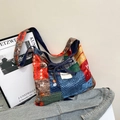 Ethno-Patchwork-Tragetasche aus Denim mit bunten Mustern auf einer Denim-Jacke - Bunt