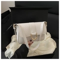 Detailed close-up of white woven texture leather bag with gold buckle in black luxury gift box - White