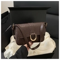 Detail of dark brown embossed texture underarm bag with decorative gold D-ring buckle - Coffee