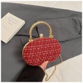 Detail der rot-goldenen Tweed-Textur einer ovalen Abendtasche mit Kristallverschluss - Rot