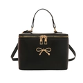 Retro black box handbag with golden bow detail and top handle on a white background - Black