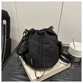 Dettaglio della borsa a secchiello nera con coulisse, tasca a rete e etichetta moda - Nero