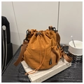 Détail du sac seau en nylon caramel avec poche latérale en filet et étiquette de mode - Marron
