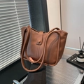 Bolso tipo cubo de cuero marrón de gran capacidad para mujer mostrado en interior - Marrón