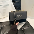 Bolso bandolera negro minimalista con textura tejida, lazo plateado y cadena - Negro