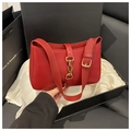 Detail view of a vintage red shoulder bag with gold piston clasp in a gift box setup - Red