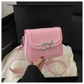 Dettaglio della borsa rosa con fibbia a fiocco argentata in una scatola da regalo - Rosa