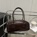 Minimalist dark brown bowling bag with silver buckles in a lifestyle scene setting - Coffee (No Pendant)