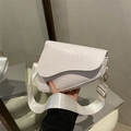 White crocodile texture saddle bag with wide strap and gold hardware in hand - White