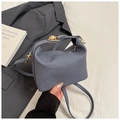 Detail der blaugrauen Handtasche mit Webstruktur, goldenem Drehverschluss und Schultergurt - Blau
