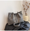 Macro shot of grey tote bag detail with metal chain strap on textured leather - Gray