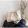 Detail of white tote bag showing premium pebble leather texture and gold chain strap - Off White