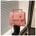 Close-up of pink vintage crossbody bag with flap cover and golden metal buckle details - Pink