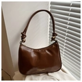 Primer plano de bolso hobo marrón oscuro con textura de cuero aceitado y nudo - Marrón
