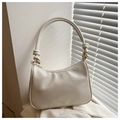 Detalle del bolso hobo crema con asa anudada y acabados metálicos dorados elegantes - Blanco