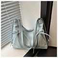 Detalle del bolso tote azul claro con cremalleras plateadas y lazos decorativos finos - Azul