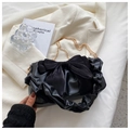 Detail of black bow shoulder bag with ruched handle and gold chain on white blazer - Black